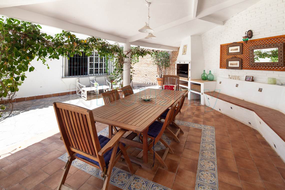 zona-con-barbacoa-en-chalet-de-el-candado amplia mesa y barbacoa en casa en venta en al candado malaga. Housmy